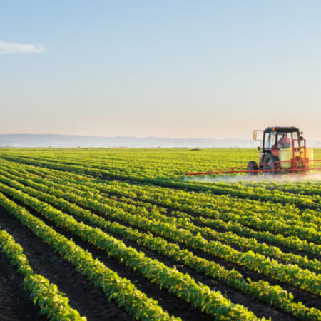 Tractor spraying soybean field